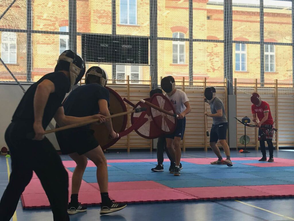 Csatárjáték mérkőzés pajzsokkal és lándzsákkal tornateremben